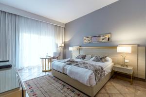 1 dormitorio con cama grande y ventana grande en Swiss Inn Pyramids Golf Resort en 6th Of October