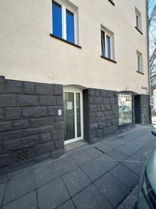 un bâtiment avec un mur en pierre à côté d'une allée. dans l'établissement S-AP Daily Room Stuttgart, à Stuttgart