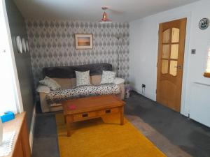 a living room with a couch and a table at Charming Eyemouth apartment close the beach in Eyemouth