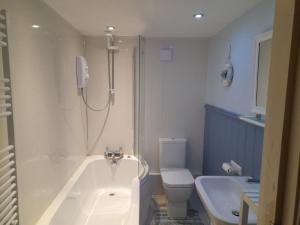 een badkamer met een bad, een toilet en een wastafel bij Charming Eyemouth apartment close the beach in Eyemouth
