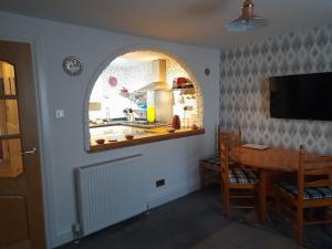 een keuken en eetkamer met een tafel en een raam bij Charming Eyemouth apartment close the beach in Eyemouth