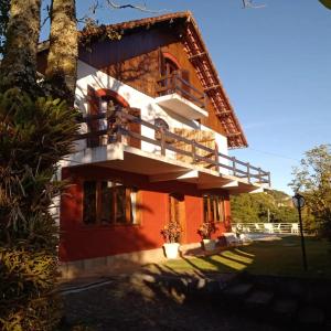 une maison avec un balcon sur le côté de celle-ci dans l'établissement Pousada Canto da Paz, à Petrópolis