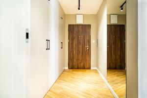 an empty room with two doors and wooden floors at ApartamentySnu, Struga Tower Silver z parkingiem in Radom