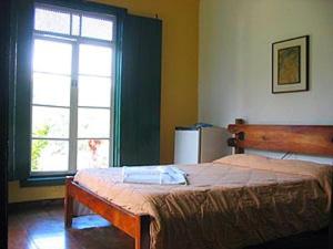 オウロ・プレットにあるHotel Pousada Hospedaria Antigaのベッドと大きな窓のある寝室