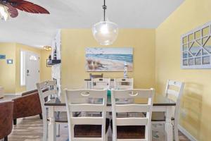 uma sala de jantar com uma mesa e cadeiras brancas em Perfect for Family Gatherings with a Heated Pool! - Clearwater's Clear Choice em Clearwater