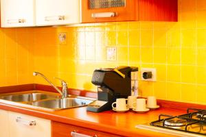 a kitchen with a sink and a coffee maker at Mereu Central Apartment in Villasimius