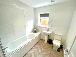 a bathroom with a tub and a sink and a toilet at Rosebank Court by Blue Skies Stays in Stockton-on-Tees