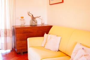 ein Wohnzimmer mit einem gelben Sofa und einem Tisch in der Unterkunft Mereu Central Apartment in Villasimius
