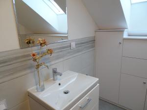 a bathroom with a sink and a vase with flowers in it at Estancja - dom wakacyjny in Mezowo +73 photos