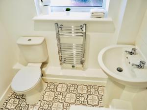 a white bathroom with a toilet and a sink at Private Parking Stylish Great Location in Guildford