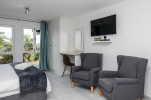 1 dormitorio con 1 cama, 2 sillas y escritorio en San Lameer Villa 2519 - Bachelor Studio - 2 pax - San Lameer Rental Agency, en Southbroom
