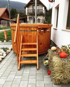 una silla de madera sentada frente a una bañera de hidromasaje en Panorámás Vendégház, en Vértestolna
