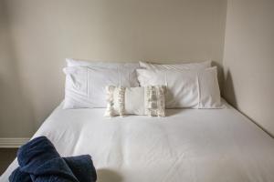 a white bed with four pillows on it at Tates Hotel Windsor in Windsor