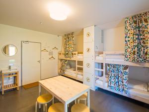 a room with bunk beds and a table and chairs at Hostel Zahrada Mikulov in Mikulov