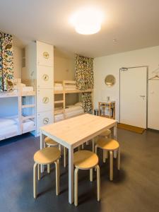 a table and chairs in a room with bunk beds at Hostel Zahrada Mikulov in Mikulov