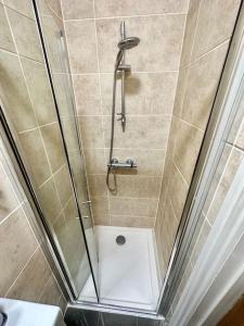 una ducha con puerta de cristal en un baño en SE4, Self contained studio flat., en Londres