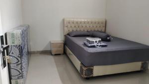ein kleines Bett in einem Zimmer mit einem Bett sidx sidx sidx sidx in der Unterkunft JM HOMESTAY in Pangandaran