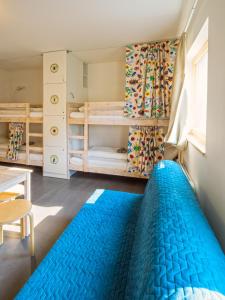 a bedroom with a blue bed and bunk beds at Hostel Zahrada Mikulov in Mikulov