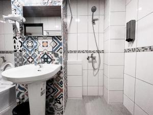 y baño blanco con lavabo y ducha. en Leisurely B&B en Taitung