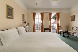 a large white bed in a room with a window at The Old Ship Aground in Minehead