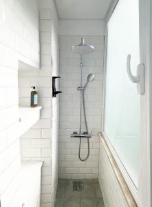 eine Dusche mit Duschkopf in einem weißen Badezimmer in der Unterkunft Cozy Lisbon Janelas Verdes in Lissabon