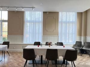 Hotel Hoevevoorde في رايسفايك: قاعة اجتماعات مع طاولة وكراسي