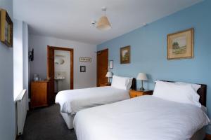 two beds in a room with blue walls at Old Ship Aground in Minehead +42 photos