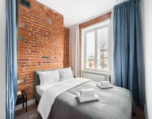 - une chambre avec un lit et un mur en briques dans l'établissement East Warsaw Modern Apartment, à Varsovie