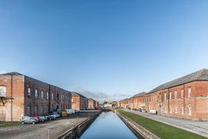 a canal between two brick buildings in a city at The Quarters in Weedon Bec