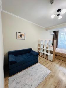 キシナウにあるCozy apartment in Chisinauの青いソファとベッドのあるリビングルーム