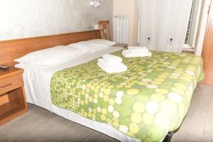 a bedroom with a bed with a green and yellow bedspread at Parri Silton in Rome
