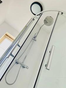 a shower with a shower head and a mirror at Lovely family house, great links M62, edge of Leeds in Liversedge