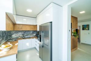 a kitchen with white cabinets and a stainless steel refrigerator at Suite Petmat in Dubrovnik