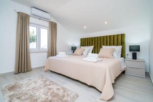 a white bedroom with a large bed and a window at Suite Petmat in Dubrovnik +43 photos