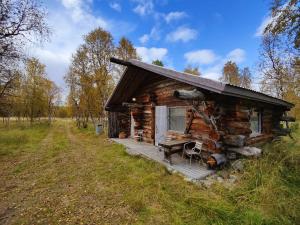 Cabaña de madera con porche y banco en la cubierta en Villa Lavijoki, en Karesuvanto