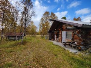 Cabaña de madera con mesa y banco al aire libre en Villa Lavijoki en Karesuvanto