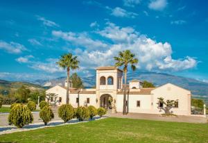 a house with palm trees and a lawn at La Esperanza Granada Luxury Hacienda & Private Villa in Saleres