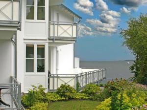 ラウターバッハにあるVilla Vilmblick - Wohnung 05 mit Terrasse und Boddenblickの水辺を見渡すバルコニー付きのホワイトハウスです。