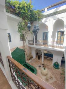 uma varanda de um edifício com uma mesa e cadeiras em Riad Dar Marrakcha em Marrakech