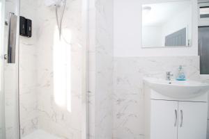y baño blanco con lavabo y ducha. en Executive Style 2 Bed Flat in Bridgend F2 en Bridgend