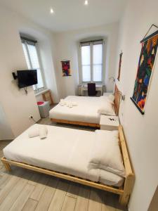 a room with two beds and a tv at Rossetti Rooms in Trieste