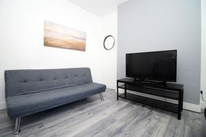 a living room with a couch and a flat screen tv at Executive Style 2 Bed Flat in Bridgend F2 in Bridgend