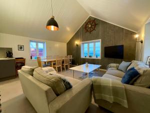 ein Wohnzimmer mit einem Sofa und einem Tisch in der Unterkunft Ocean View Tind Lofoten in Moskenes