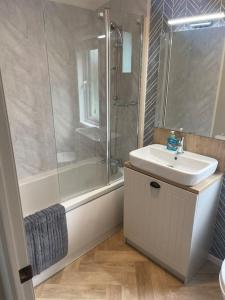 La salle de bains est pourvue d'une douche, d'un lavabo et d'une baignoire. dans l'établissement Snittlegarth Farm Lodges, à Wigton
