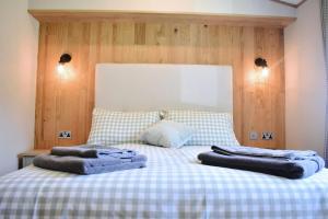 a bed with two towels on top of it at Snittlegarth Farm Lodges in Wigton