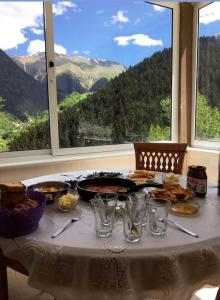 una mesa con comida y copas y vistas a las montañas en Hamsiköy Dağ Evi, en Macka
