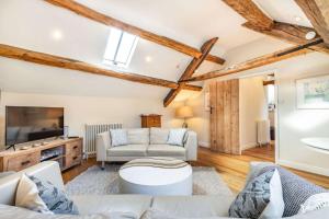 a living room with a couch and a tv at The Hayloft in Notgrove