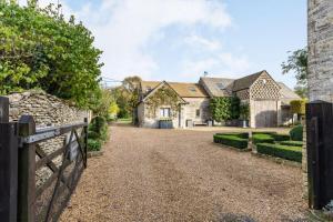 a house with a fence and a driveway at The Hayloft in Notgrove