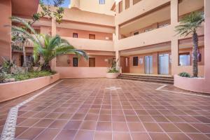 an empty courtyard of a building with palm trees at Don Juan Beach Resort in Estepona