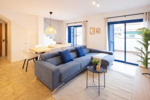 sala de estar con sofá azul y mesa en Lucas House Apartments by Sitges Group, en Sitges